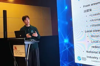 Man speaking at podium in front of a projector