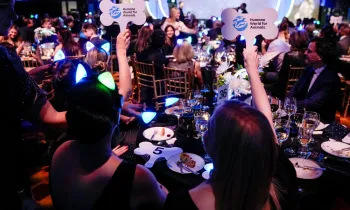 a group of people sitting at a table holding signs
