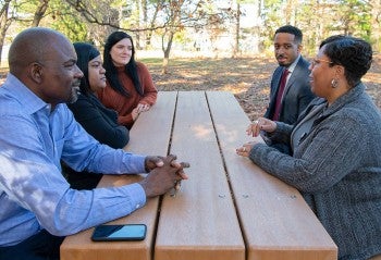 Group of HSUS staff meet at outdoor picnic table to have a small meeting