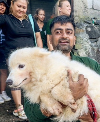 Man holding a dog outside