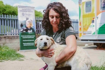 A woman holds a dog