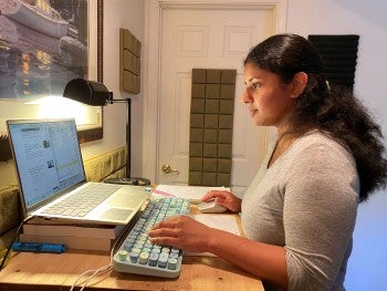 A woman sitting at the computer, typing