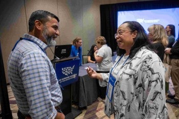 Two people talking at a conference