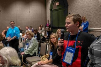 A young boy asks a question during a forumn