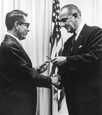 Old photo showing President Johnson shaking hands with HSUS investigator Frank McMachon in 1966.