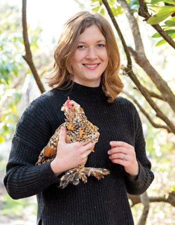 Portrait of Tove Danovich holding a chicken.