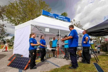A group of responders stand near a tent