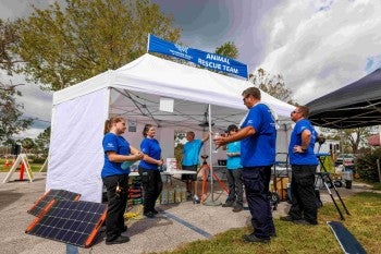 A group of responders stand near a tent