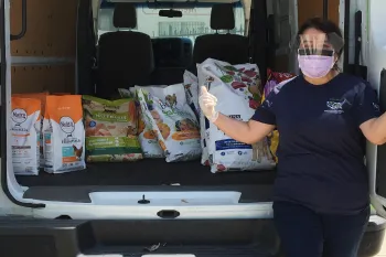 Pets for Life staff member with a van full of supplies