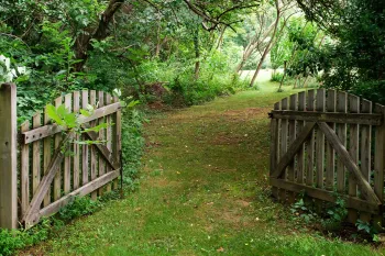 open gate leading into a lush green garden