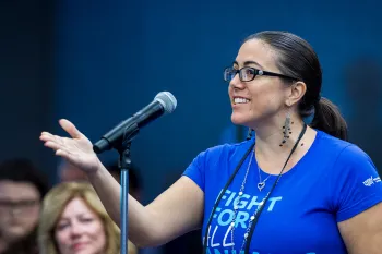 A smiling woman speaks into a microphone