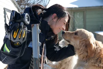 Intern Ashley Mauceri rubs noses with a dog