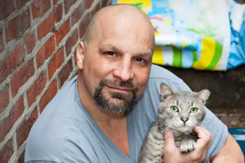 Man holding his grey cat