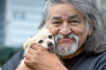 A man holds his dog at HSUS’s Rural Area Veterinary Services (RAVS) program, Taholah, Quinault Nation, WA.