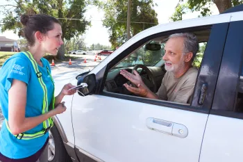 An HSUS volunteer assisting a visitor at the pet supply distribution center in Florida.