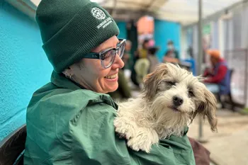 Woman smiling and holding dog