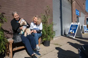 Two people laughing with small dog