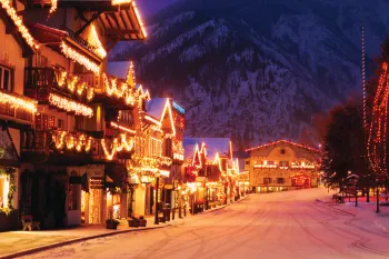 A snow covered street filled with lights at night.
