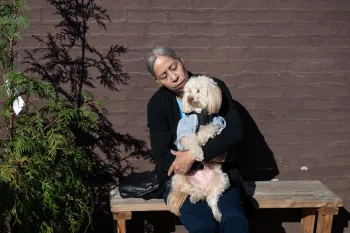 Woman holding a dog outside