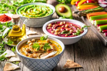 Various vegan dishes set on a table with other vegetables