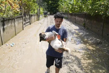 Man carrying dog in flood