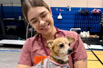 A woman holding a small dog