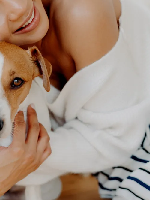 A woman hugs her dog goodbye, but he looks sad and doesn't want her to leave