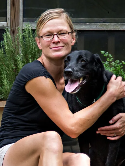 Woman and her black dog on back porch of their home