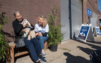 Two people laughing with small dog